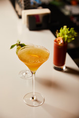 selective focus of cold cocktails in glasses on bar stand