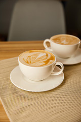 selective focus of cappuccino in white cups on table