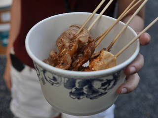 Spicy bbq on a white plate in the hands of people