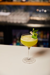 glass with mixed alcohol cocktail with gin on bar counter