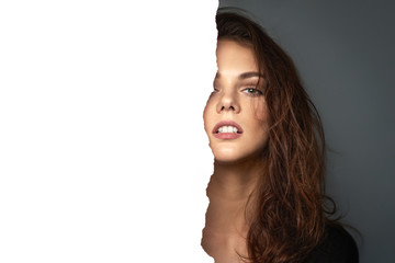 Emotional portrait of a beautiful girl against a background in studio