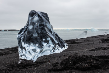 Big block of ice on black sand beach, Jökulsárlón Iceland
