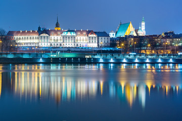 Old Town with reflection in the Vistula River during evening blue hour, Warsaw, Poland.