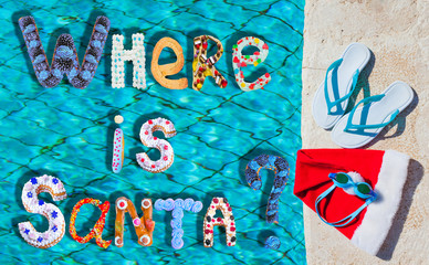 Where is Santa? Cakes, eclairs, donuts, marshmallows,  sweets bakery font. New year and Xmas greeting card concept. Santa Claus hat, Christmas vacation, slippers and pool goggles near pool