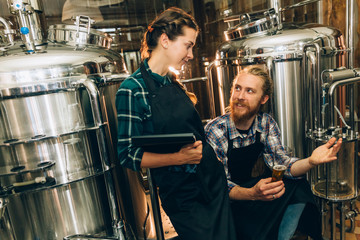 Portrait of Brewery workers. Male and female brewer at brewery factory. 4k. Small business concept.