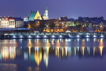 Royal Castle in Old Town with reflection in the Vistula River during evening blue hour, Warsaw,...