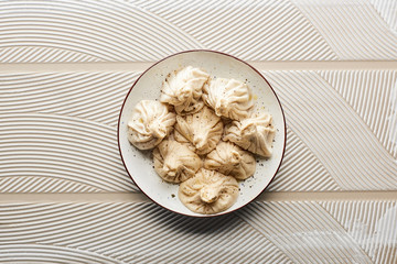 top view of fresh delicious khinkali on textured beige background