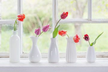 spring flowers in white vase on old windowsill