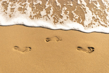 Fototapeta na wymiar Human footprints on the sand beach. Sunny.