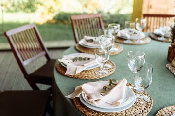 Festive table with green tablecloth decorated with flowers and candles