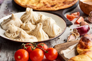 selective focus of Imeretian and Adjarian khachapuri, khinkali on wooden table
