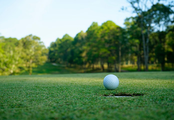 Golf ball on green in the evening golf course with sunshine in thailand