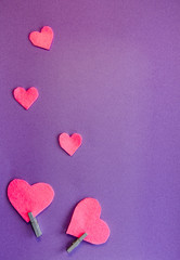 Pink felt hearts on a purple background. Flat lay. Happy Valentine.