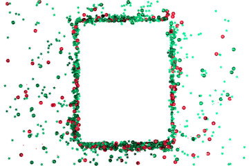 Christmas holiday composition. Frame made of red and green star confetti on white background....