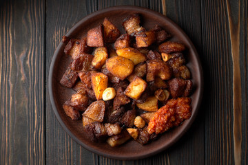 Obraz na płótnie Canvas Homemade potato with meat, garlic, adjika, on wooden background