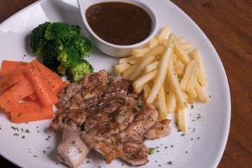 Grilled chicken chop with fresh carrot, broccoli and french fries served with black pepper sauce. Hot Meat Dishes. Top view, flat lay.