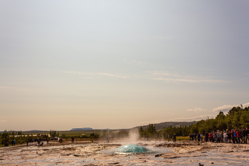 People watching geyser right before eruption, crowd watchinggeyser erupting first moment