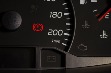 Parking brake indicator lamp in the dashboard of the vehicle is lit in red