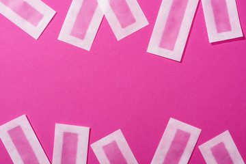 top view of wax depilation stripes on pink background