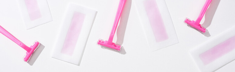 top view of pink razors and depilation wax stripes on white background, panoramic shot