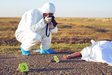 Detective studying a crime scene taking photographs.