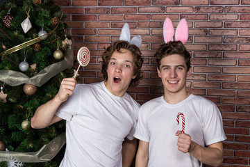 Two funny guys in suits rabbits celebrating christmas over brick wall