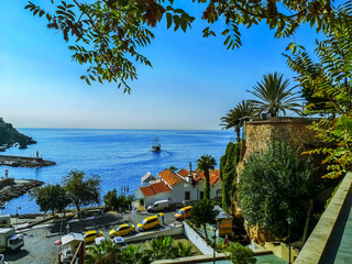 Seascape in the Old Port of Antalya (Turkey). Beautiful tropical view with palm trees, old architecture and a ship in the sea