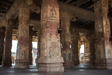 Fototapeta premium Carved stone columns in an ancient temple. The ruin of ancient temples near the village of Hampi. Krishna Temple. India