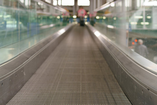 Photography of escalator in the airport in day time. Nobody here, free way. Image with defocused background. Travelling and touristic concepts.