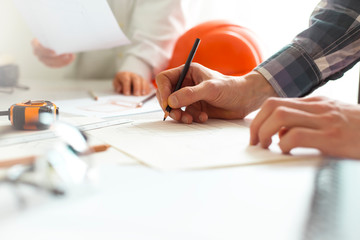 A team of architects develop a drawing for construction projects. Engineers create a sketch at the...