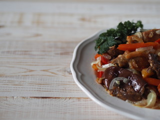 rabbit stew with vegetables on a white rustic wooden table