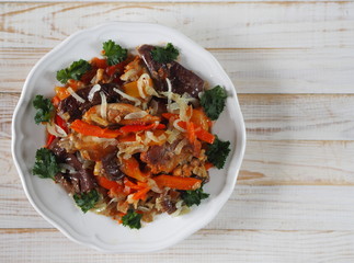 rabbit stew with vegetables on a white rustic wooden table
