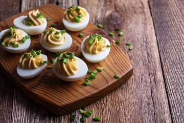 Deviled eggs on rustic wooden background