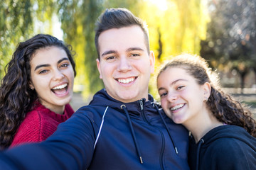 Fototapeta premium Three friends taking a selfie on a park