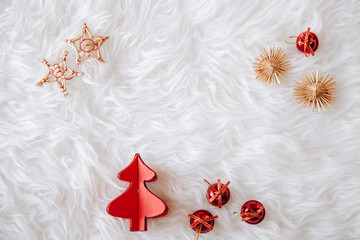 top view of Christmas composition on white snowy background for greeting card. wood xmas tree and little christmas red balls