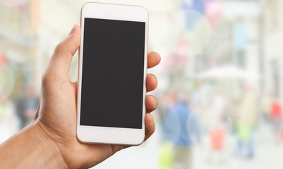 Hand holding smartphone  on blurred city background