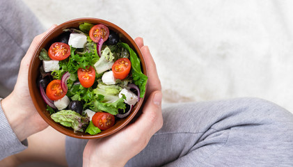 Plate with vegetable salad in woman hands