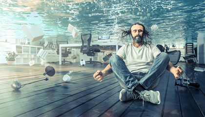 man sitting underwater who relaxes in a yoga position.