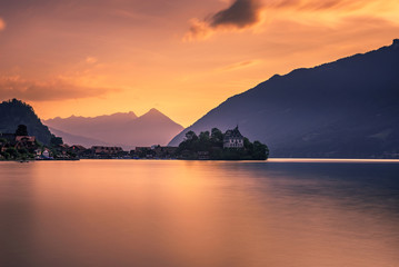 Sunset above Iseltwald peninsula and former castle in Switzerland