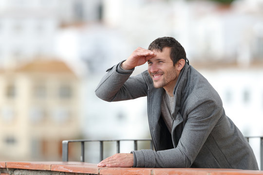 Happy Man Contemplating With Hand On Forehead