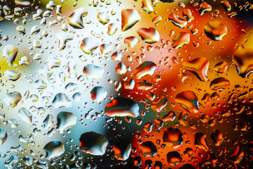 Neon lights behind water drops close up