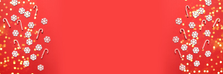 Christmas background with snow decorations, candy cane on red background. Christmas, winter, new year concept. Flat lay, top view, copy space