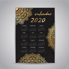 Calendar design for the new year 2020. Beautiful decorative mandala elements in gold color. The week starts on Sunday