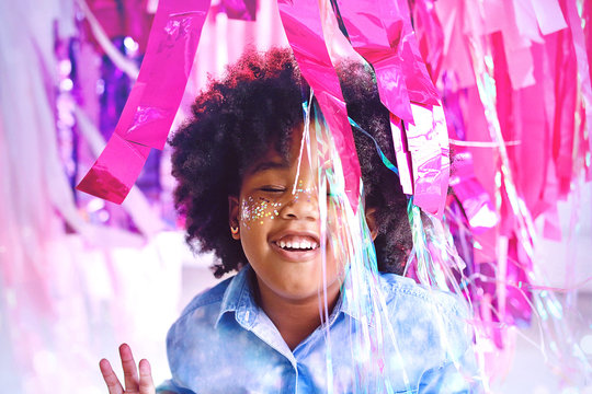 Happy African American Child Smiles While Playing with Confetti