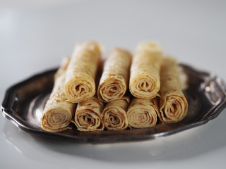 pancakes with sour cream and jam on a metal plate on a white table