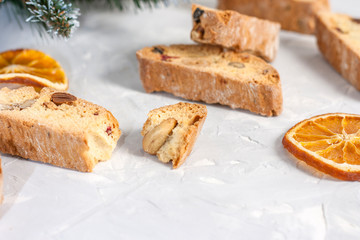 Tasty traditional Italian homemade biscotti or cantuccini cookies with hazelnuts, almonds and walnuts on a light gray background.