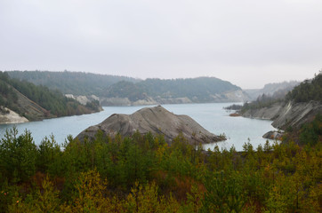 Artificial lake was is formed after the extraction of chalk in an industrial quarry at Krasnoselsky village in the Belarus. Water in open pit between the mountains. Belarusian Maldives