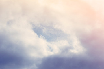Blue sky with clouds illuminated by the rays of the sun. Background