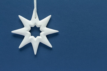 Christmas composition. White star on blue background top view background with copy space for your...