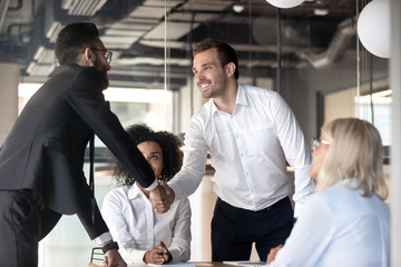 Smiling male partners handshake greeting at business meeting